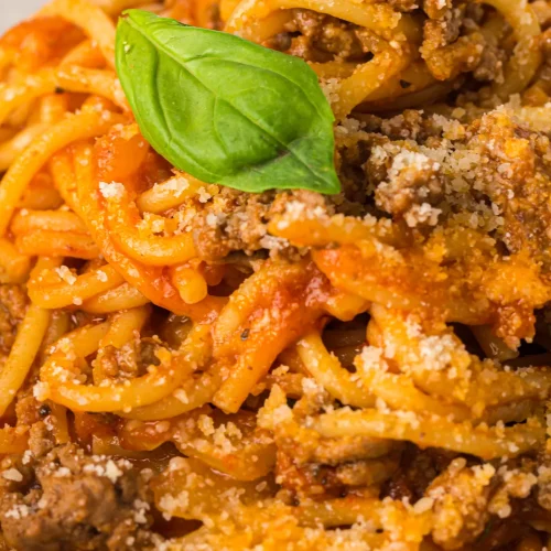 Instant pot spaghetti twirled on a plate with basil and grated parmesan