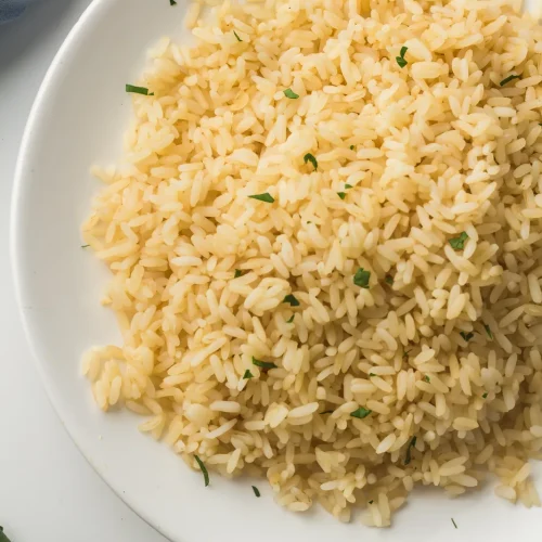 Fluffy instant pot white rice served on a white plate with chopped parsley
