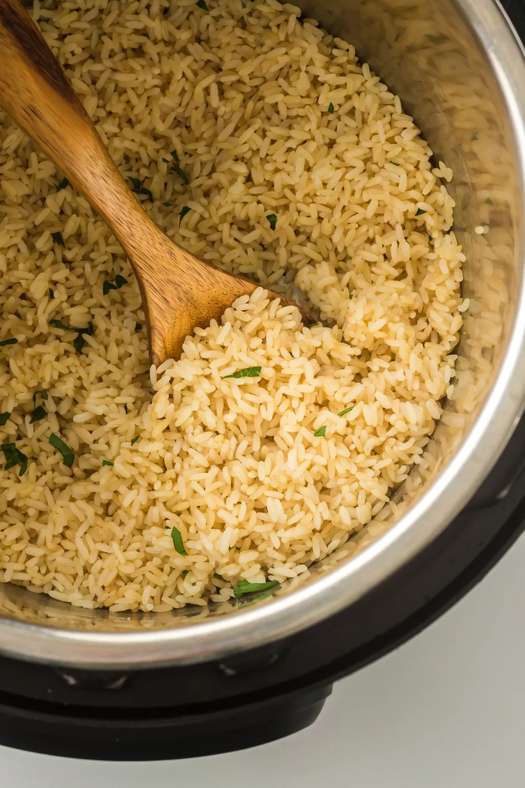 Cooked grains and a wooden spoon in the inner pot after the lid came off