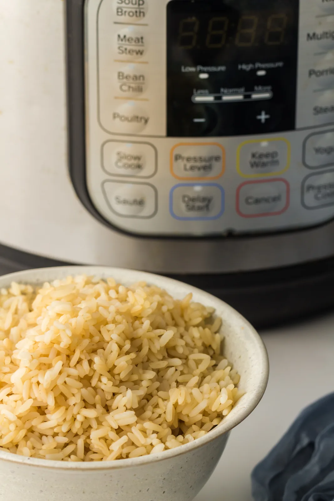A bowl of hot fluffy grains in front of the pressure cooker control panel