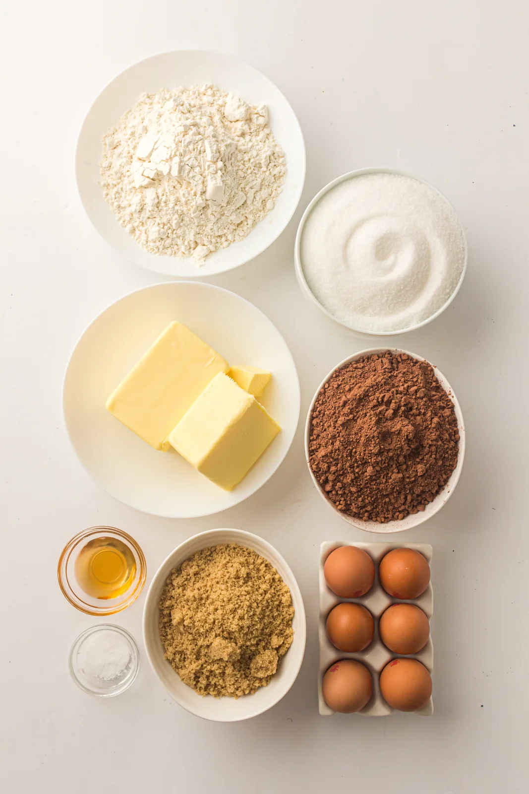 Ingredients for sheet pan brownies: butter, granulated and brown sugar, cocoa powder, eggs, vanilla, flour and salt