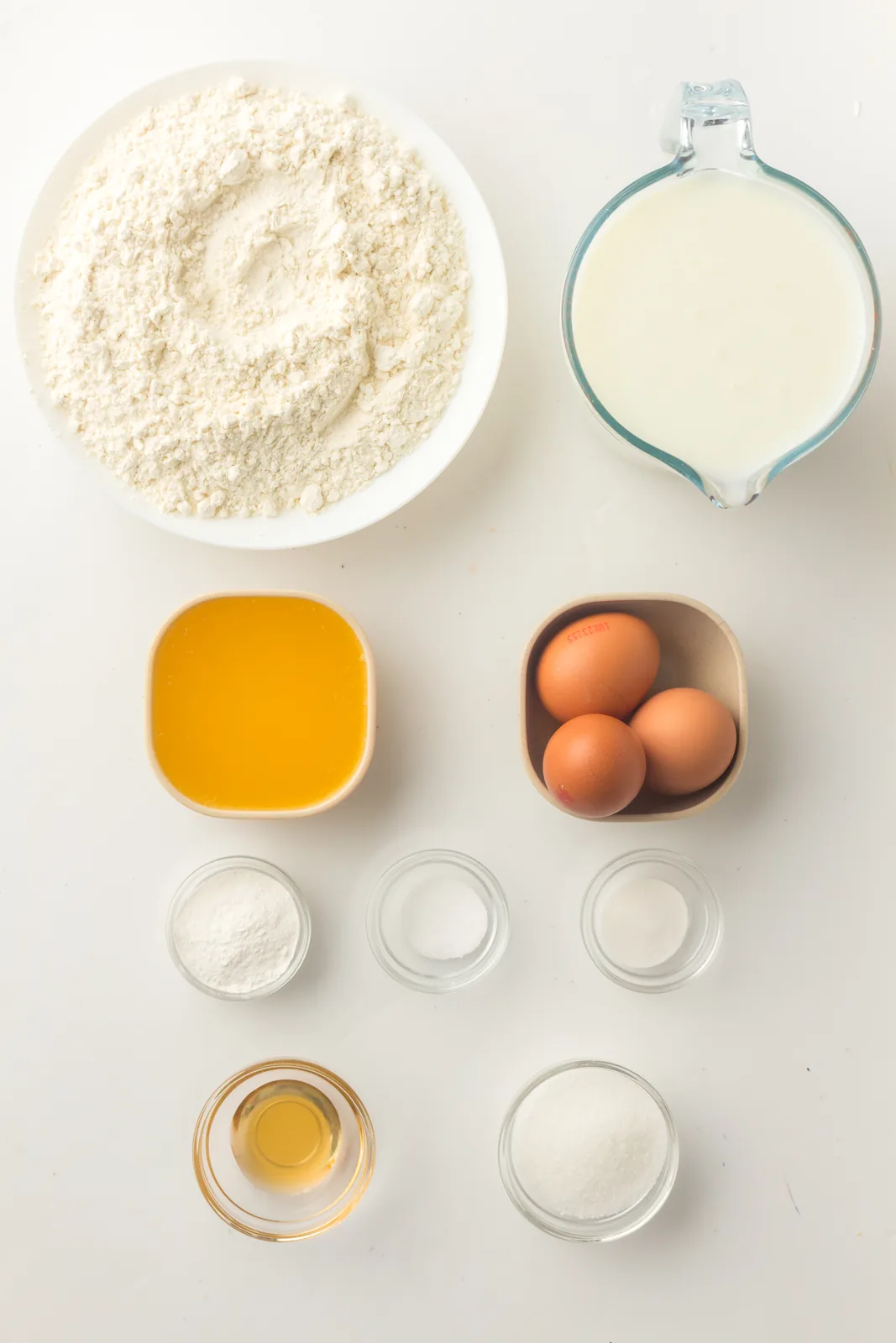 Ingredients for sheet pan pancakes: flour, sugar, baking powder, baking soda, salt, buttermilk, eggs, butter and vanilla