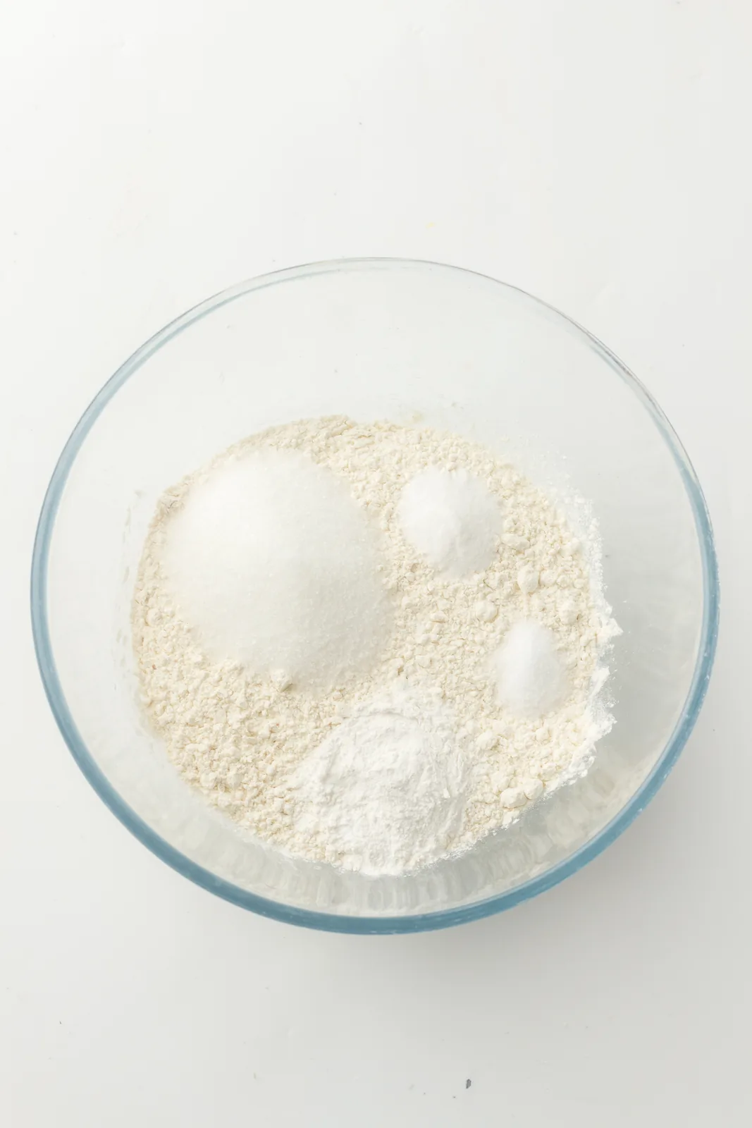 Flour, sugar and raising agents measured into a glass mixing bowl