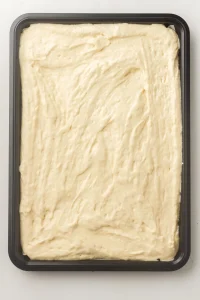 Batter spread evenly across a parchment lined baking tray