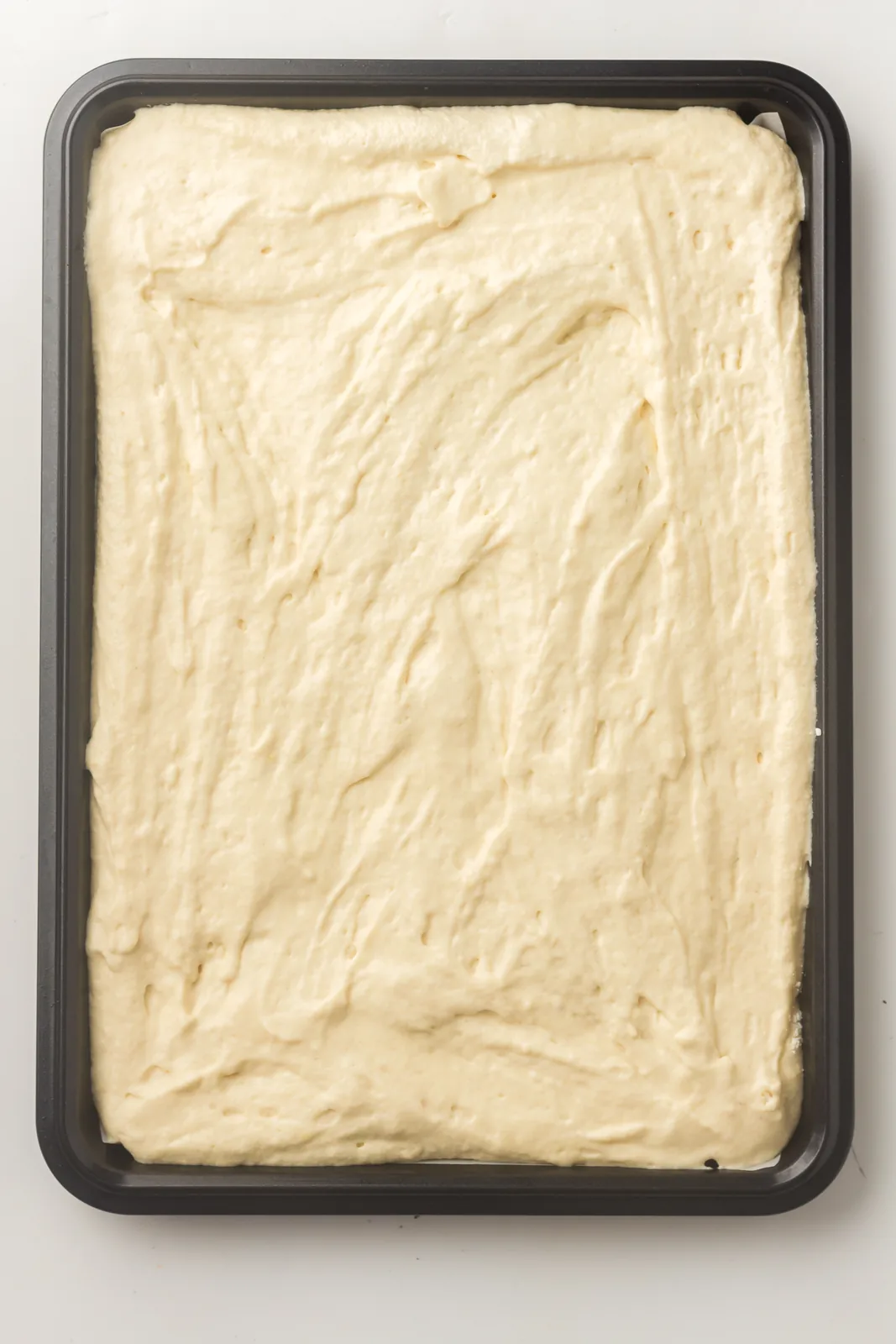 Batter spread evenly across a parchment lined baking tray