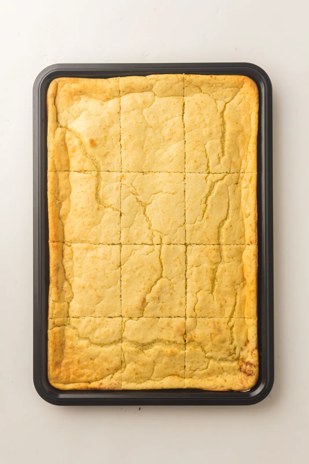 The finished golden slab cut into neat squares in the tray