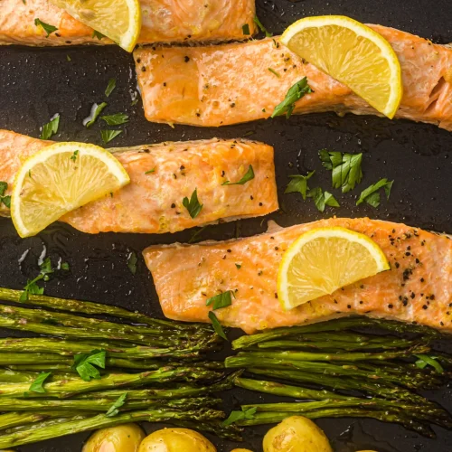 Sheet pan salmon with lemon slices, roasted potatoes and asparagus on the tray