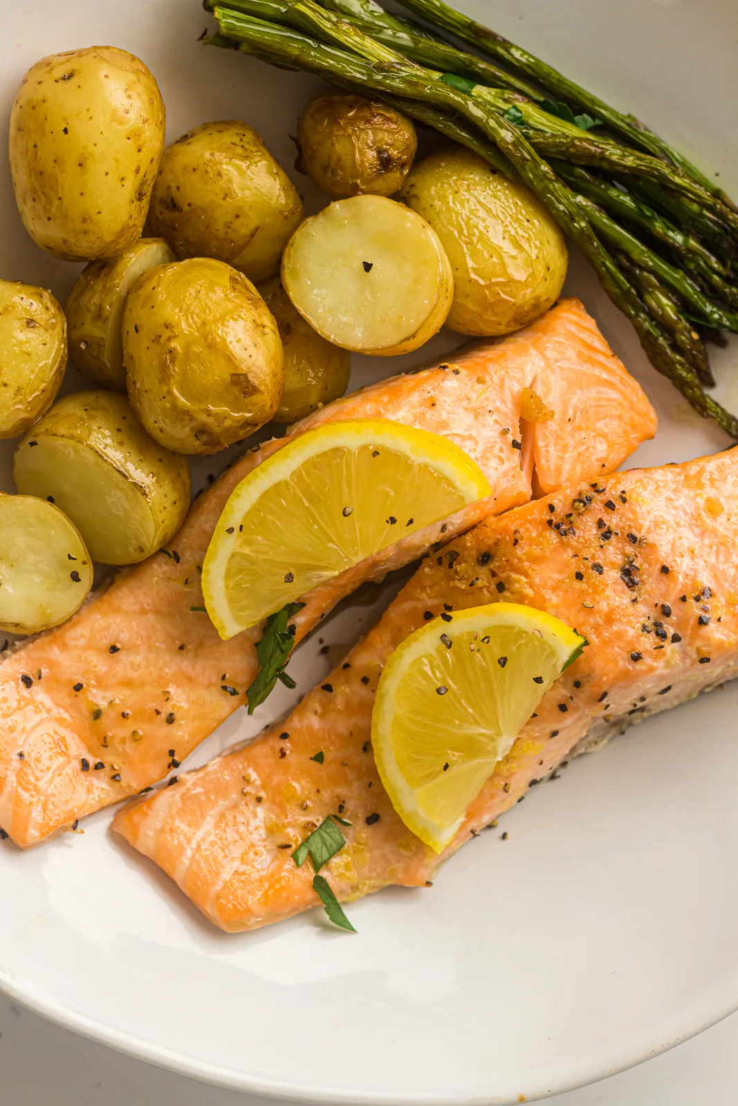 A plated fillet with roasted baby potatoes, green spears and a wedge of lemon