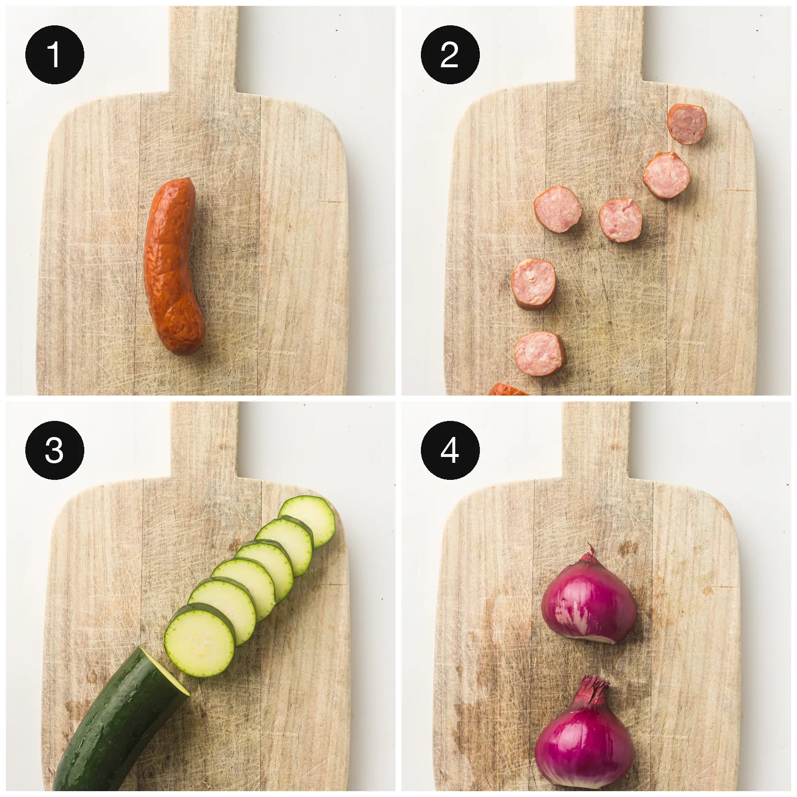 Smoked sausage sliced into rounds with courgette coins and red onion wedges on a wooden board