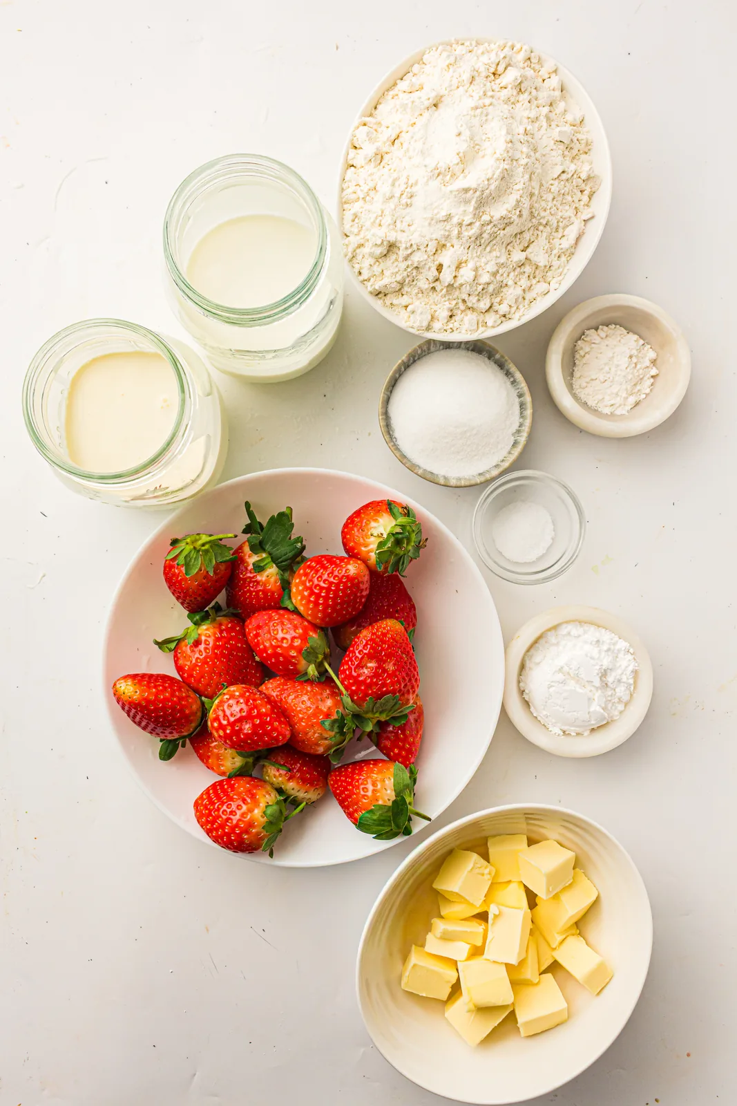 Ingredients for strawberry shortcake: flour, butter, milk, berries and cream