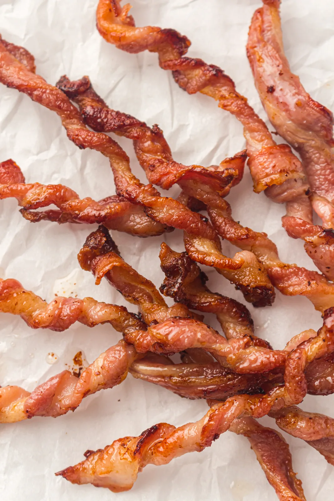 Crisp spirals of streaky rashers scattered across crumpled baking paper