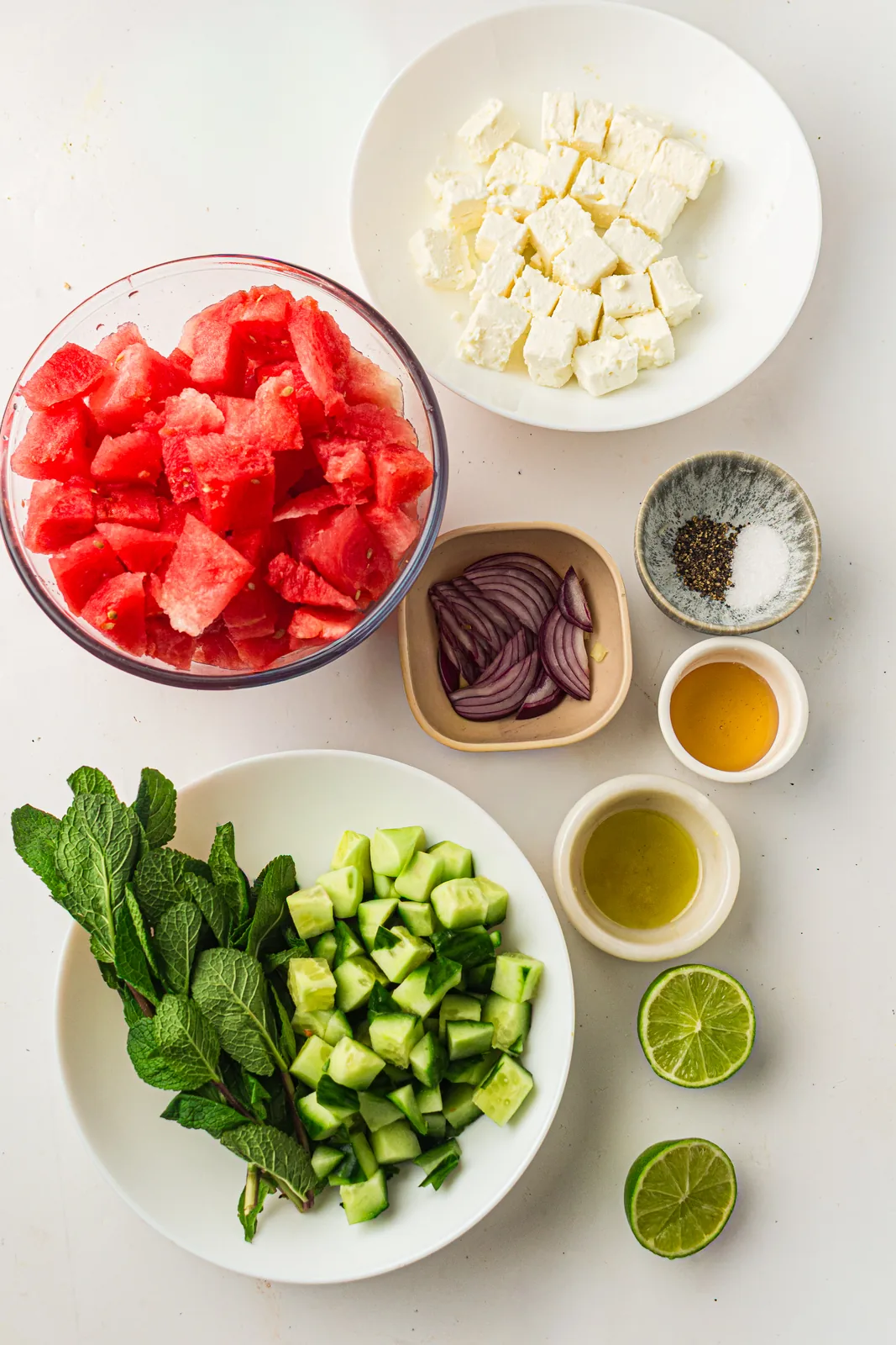 Ingredients for watermelon salad: melon, feta, cucumber, red onion, mint and lime