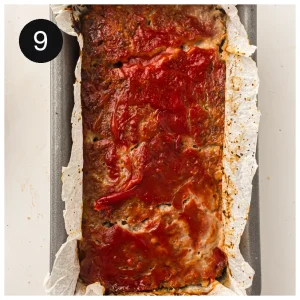 The baked loaf on a lined baking tray, glossy and browned at the edges