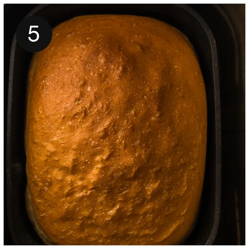 The finished golden loaf resting in the machine pan