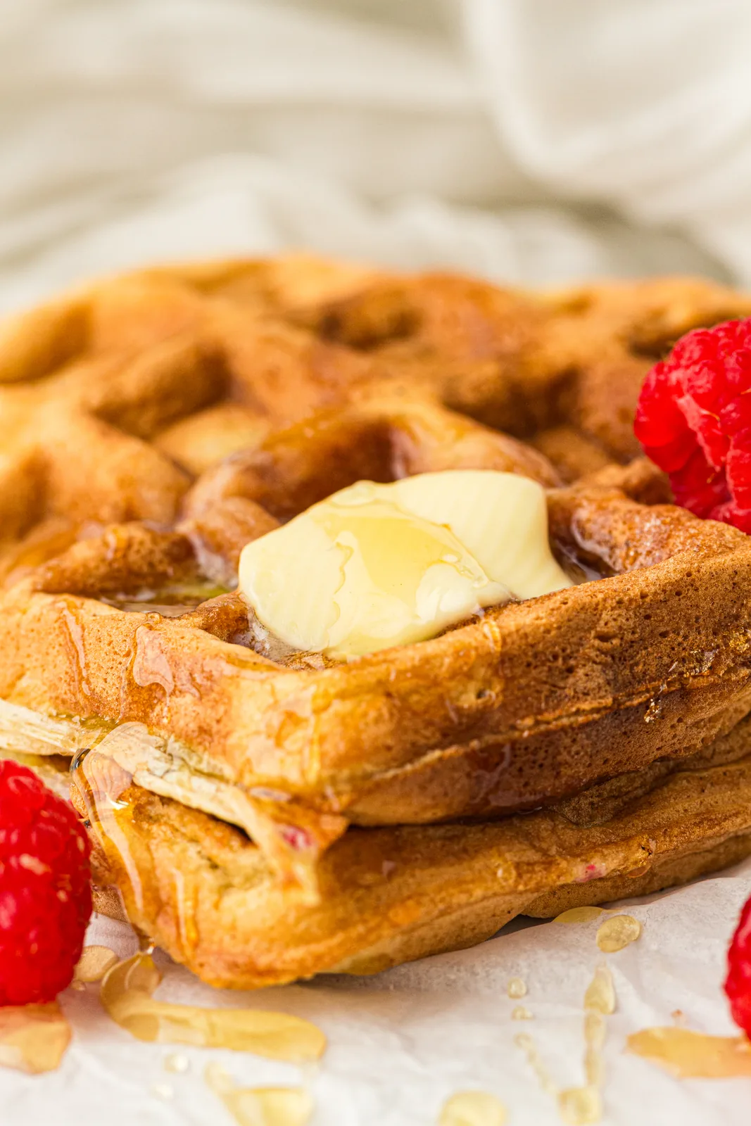 Fresh berries and a curl of butter beside warm raspberry sourdough waffles