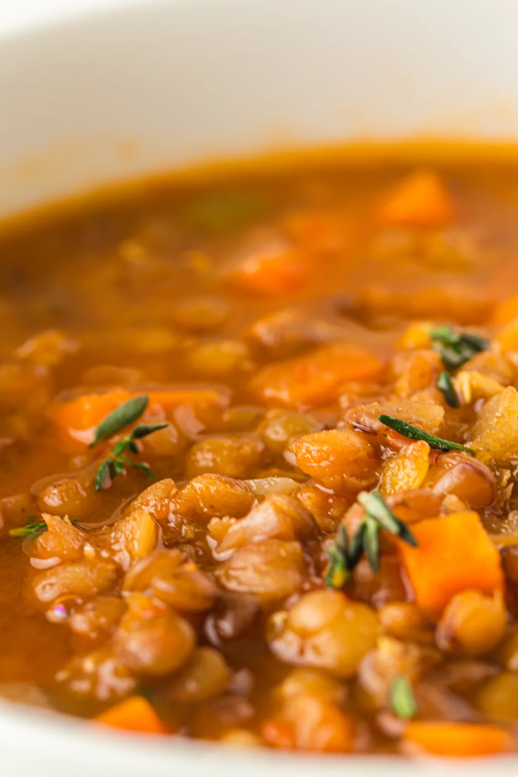 A bowl of the brothy pulses topped with fresh thyme