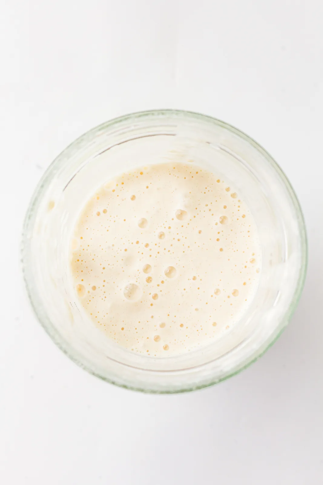 A bubbly active starter domed in a glass jar