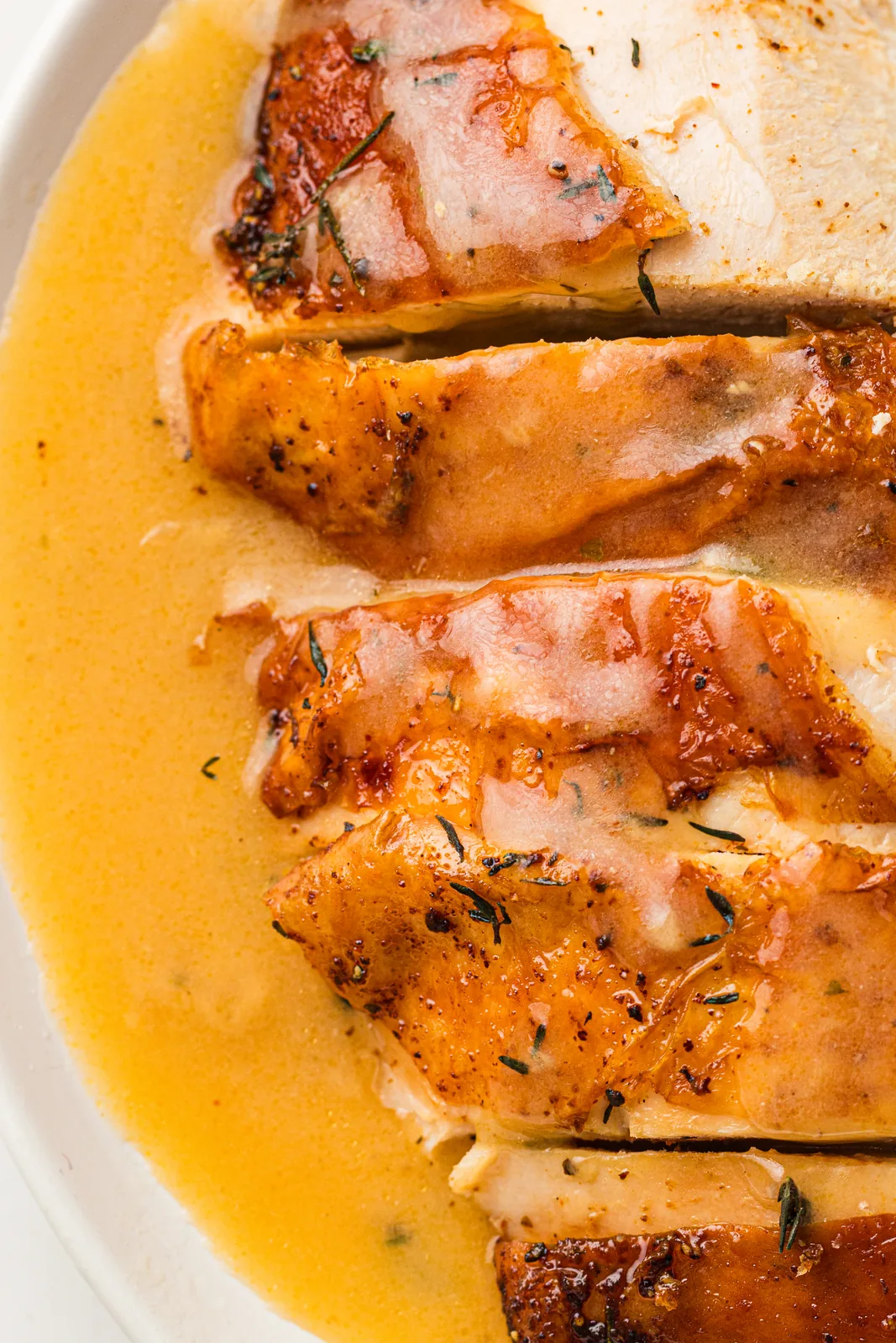 Carved slices of white meat under a glossy savoury sauce