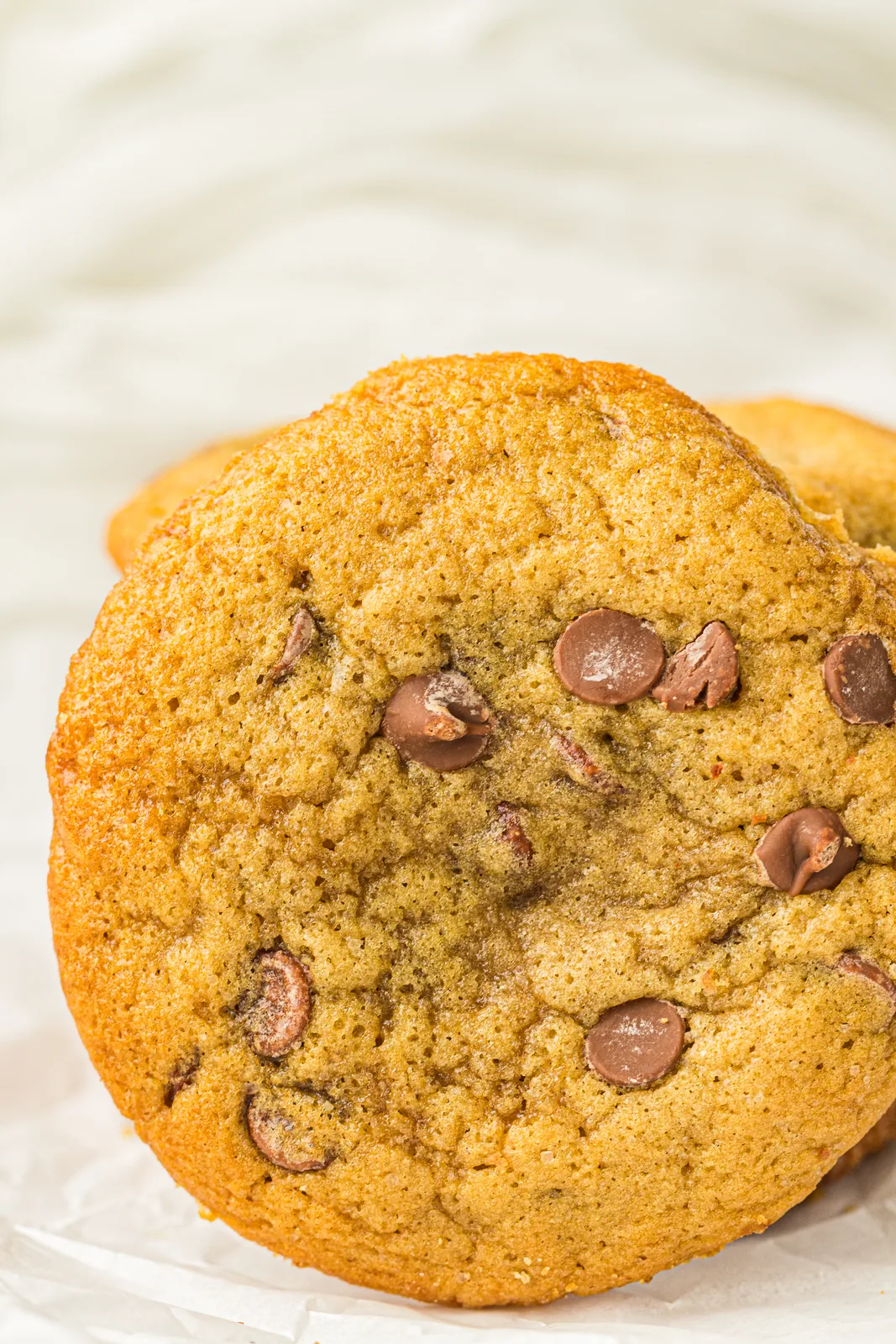 Close up of a golden chocolate studded round on parchment