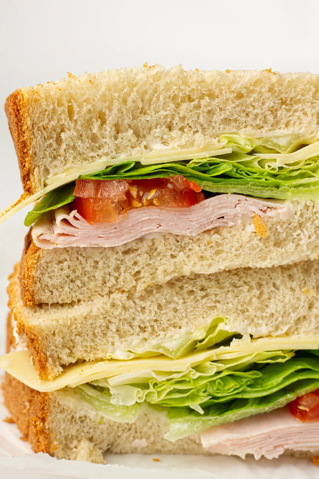 A stacked sandwich built from homemade slices with ham, cheese and salad