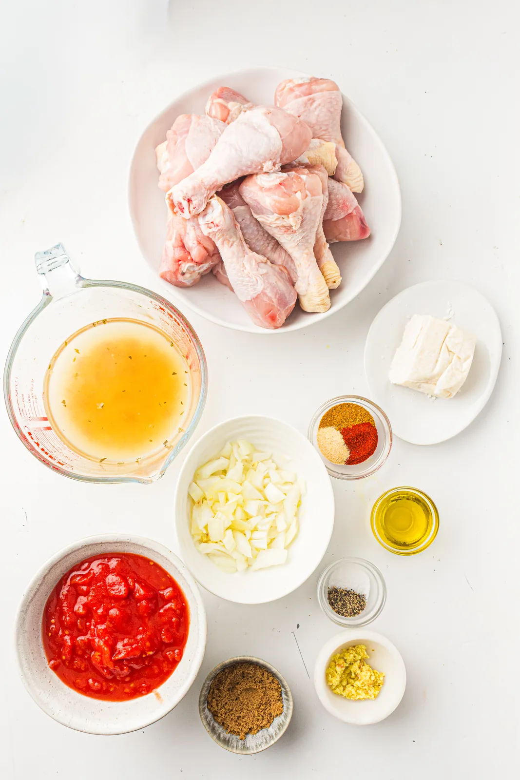 Ingredients for coconut chicken curry: drumsticks, creamed coconut, chopped tomatoes, onion, garlic, ginger, curry powder and oil