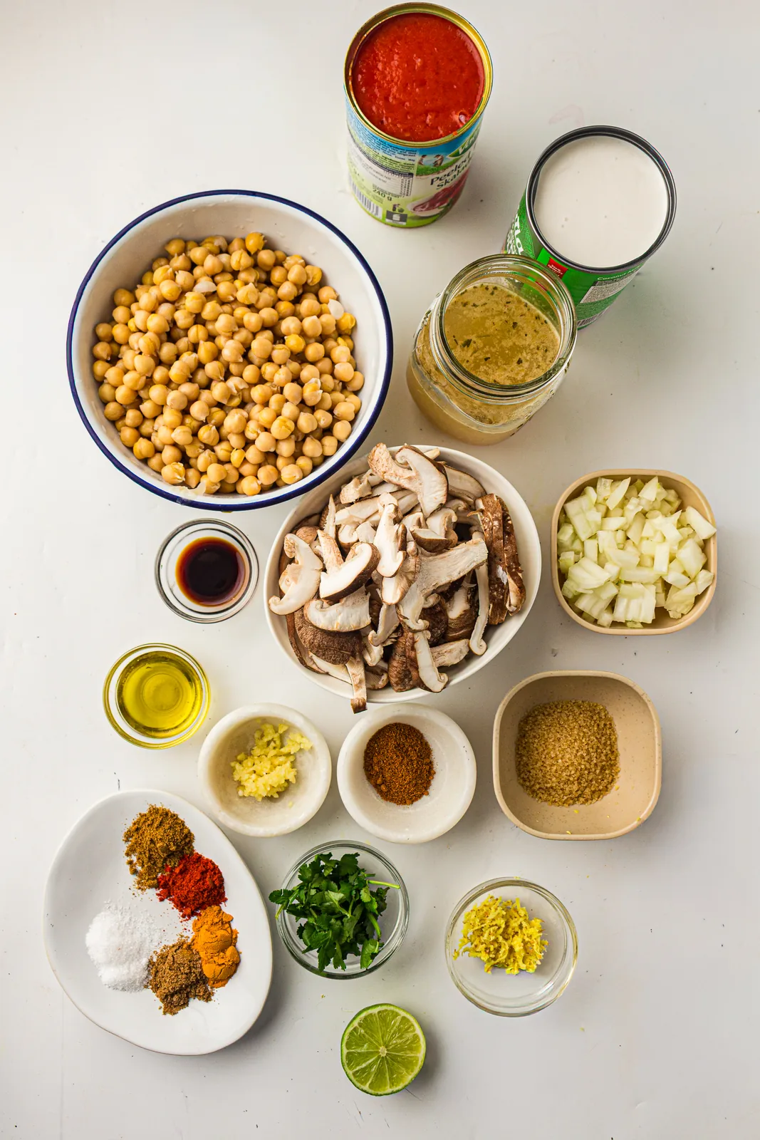 Ingredients for coconut chickpea curry: chickpeas, coconut milk, chopped tomatoes, shiitake mushrooms, onion, garlic, ginger, lime and spices