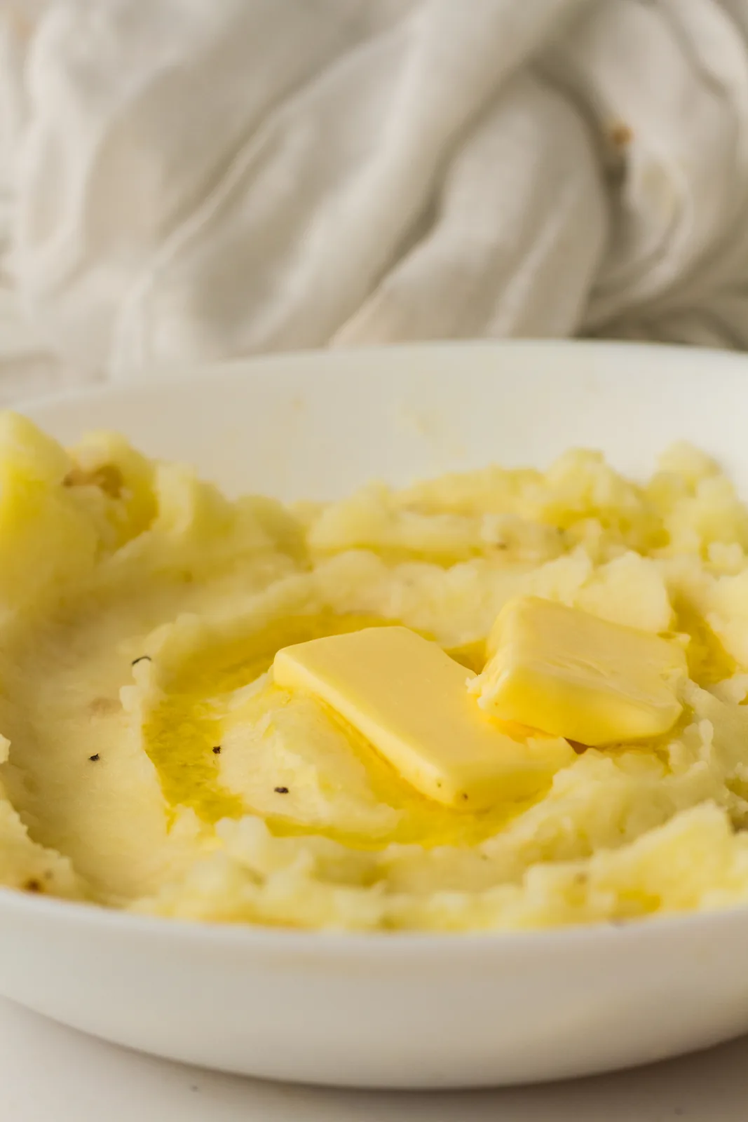 A shallow white dish of silky pale puree with a golden pool in the middle