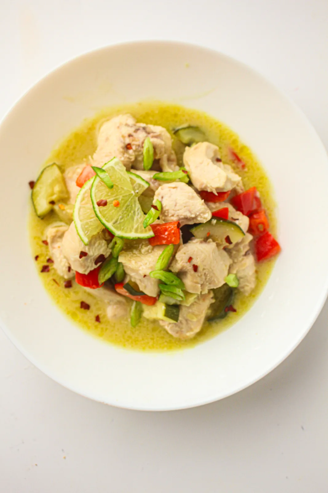 Creamy pale sauce with diced red pepper and a lime slice on top