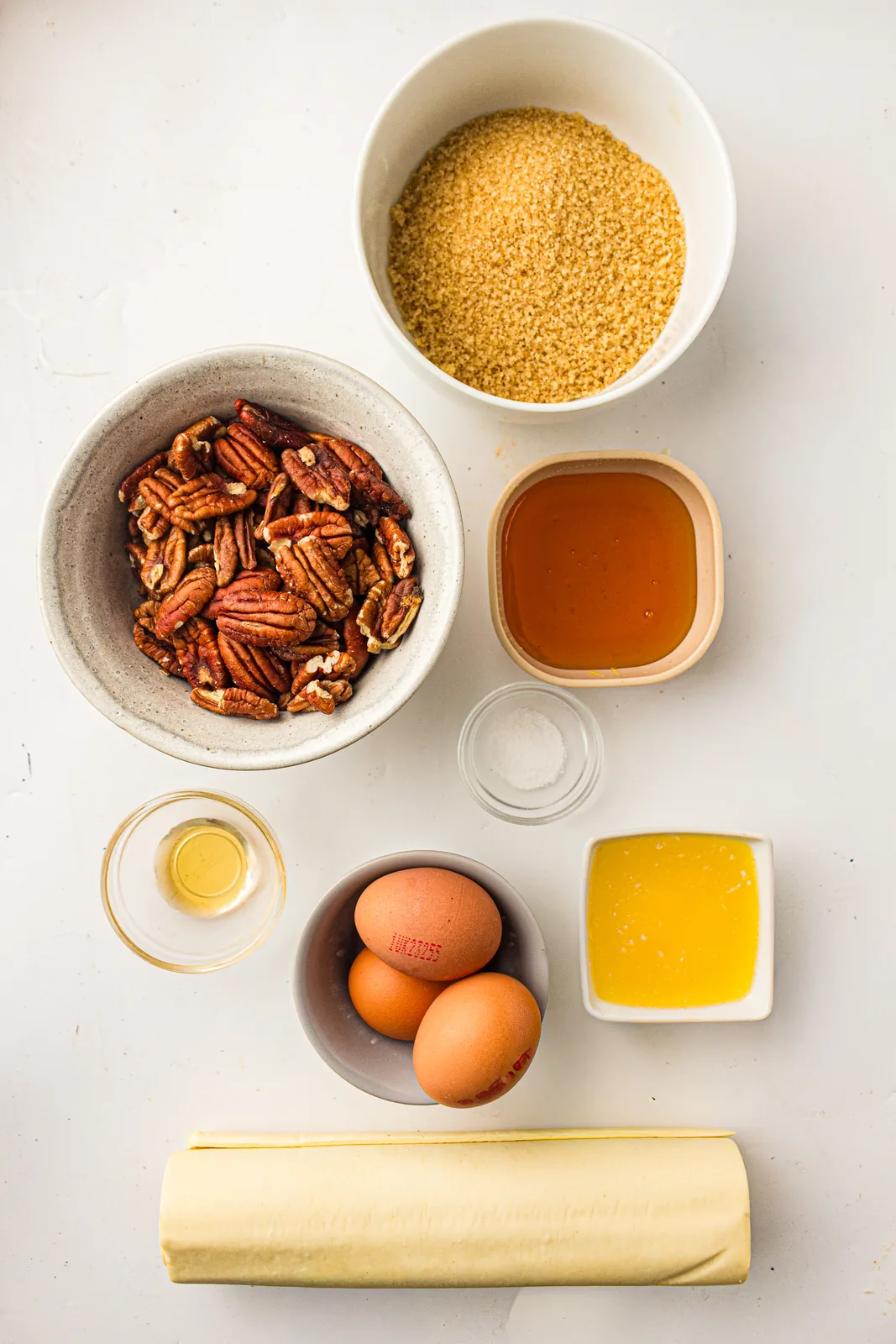 Ingredients for easy pecan pie: pecans, brown sugar, syrup, eggs, melted butter, vanilla and pastry