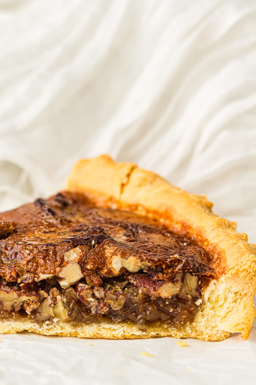 A slice of easy pecan pie showing the nutty caramel filling and crisp pastry base