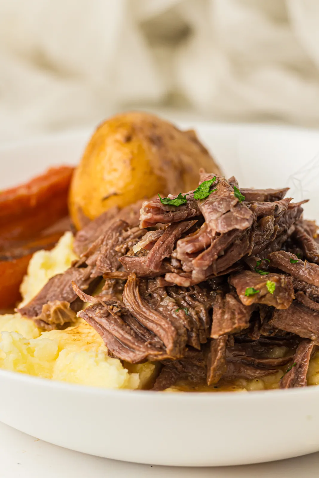 Fork tender beef with a whole potato and a chunk of carrot