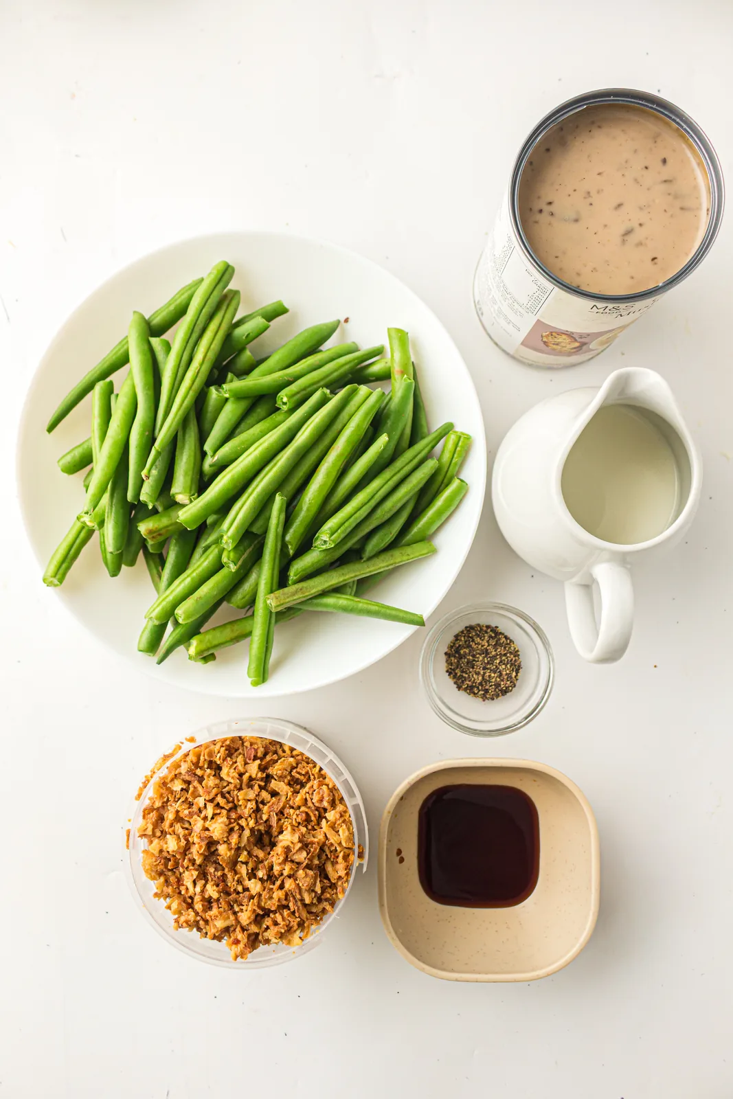 Ingredients for fresh green bean casserole: trimmed beans, condensed soup, milk, pepper and crispy onions