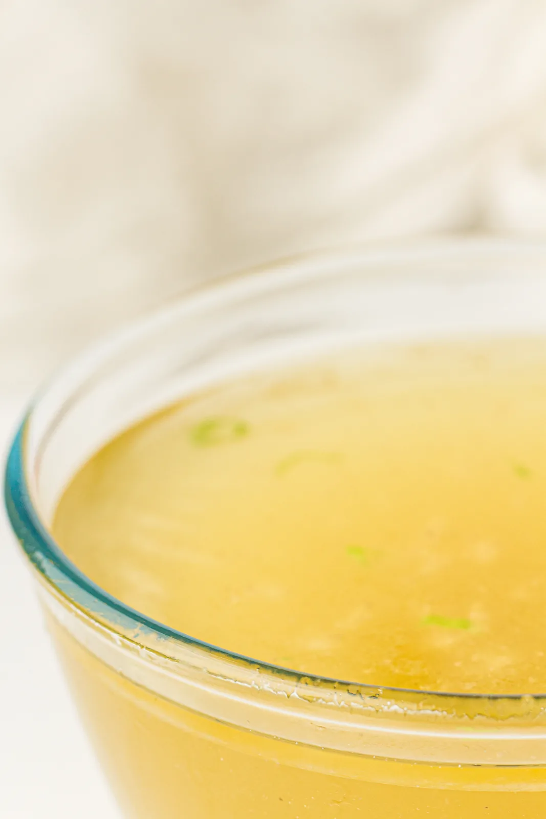Golden liquid filling a wide glass bowl on a white cloth