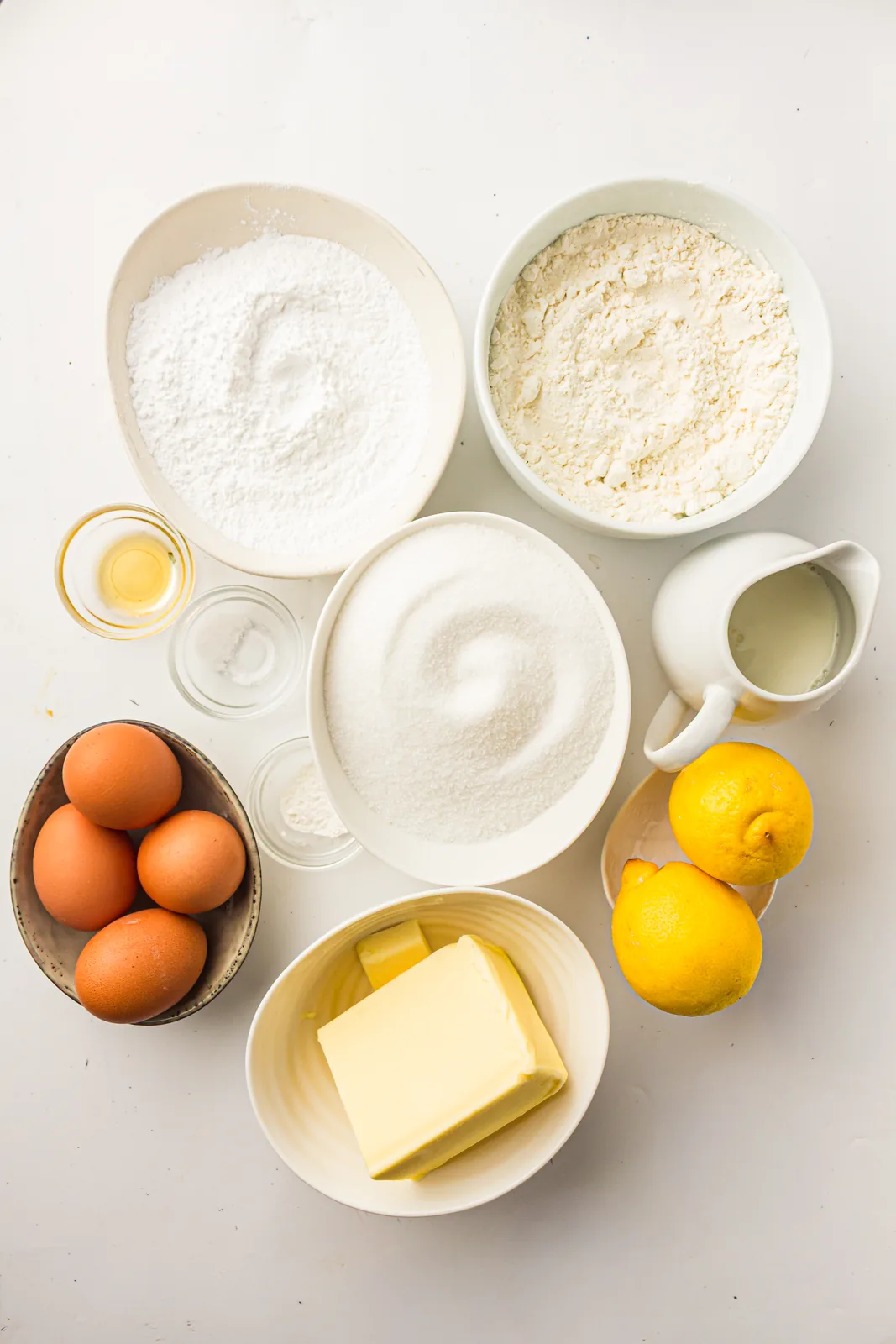 Ingredients for lemon pound cake: butter, sugar, eggs, flour, milk, vanilla, lemons and icing sugar
