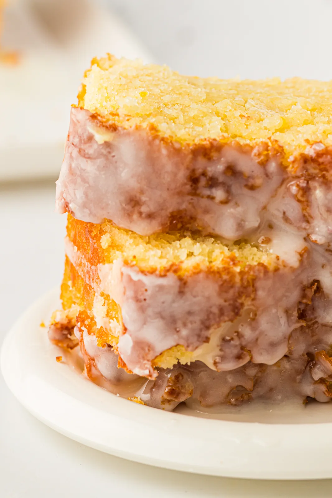 Lemon pound cake sliced to show the golden crumb under a white glaze