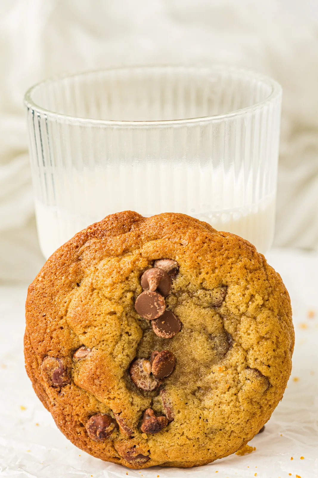 One golden bake propped beside a tall glass of milk