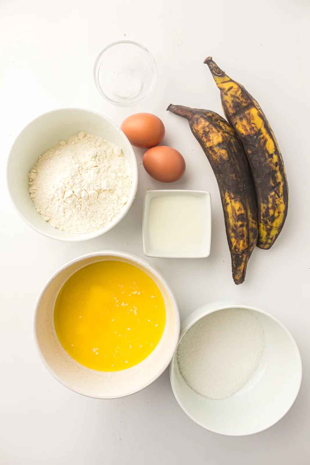 Ingredients for plantain bread: two very ripe plantains, eggs, melted butter, sugar, self-raising flour and milk