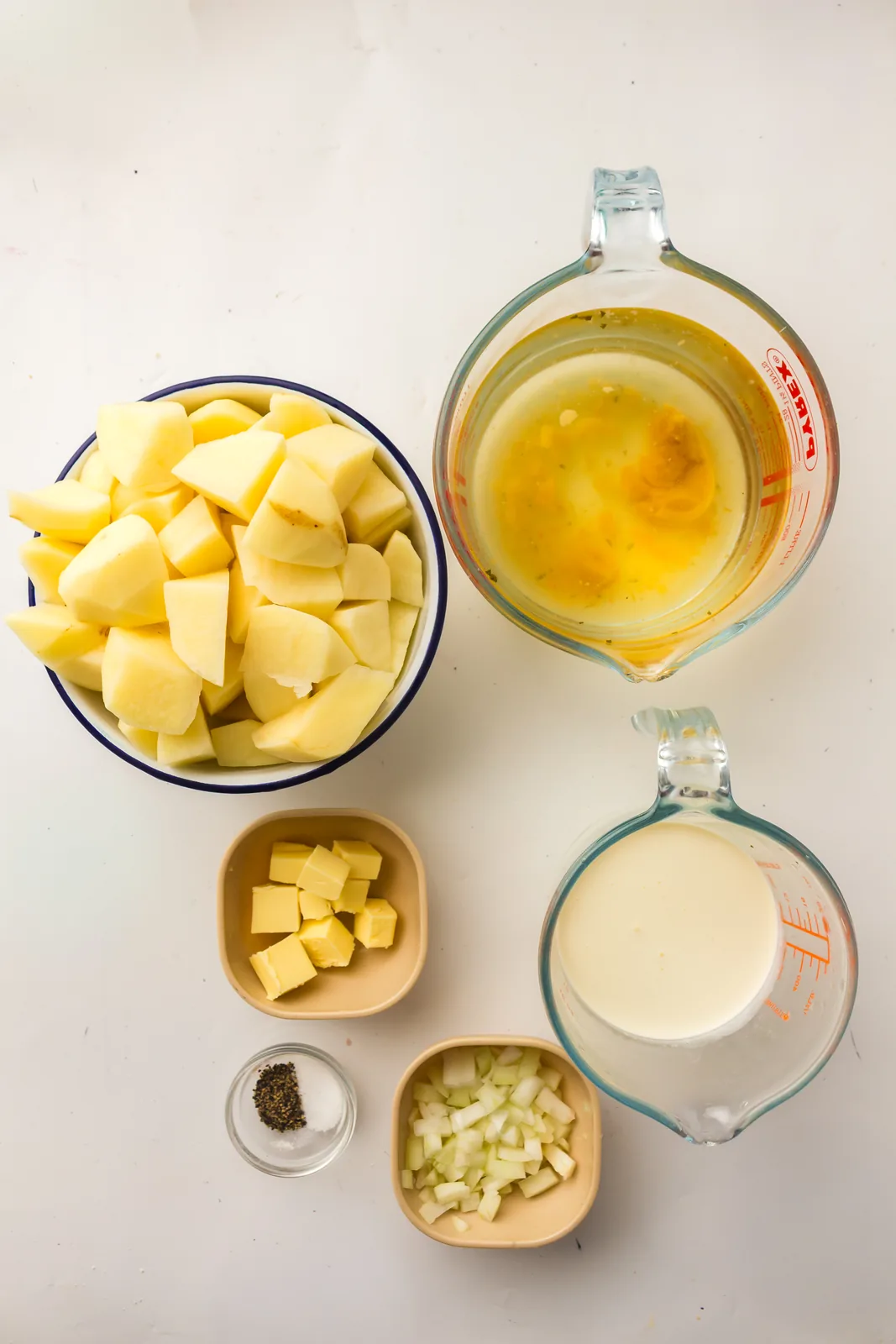 Ingredients for potato soup: diced potatoes, onion, butter, stock, milk, salt and pepper