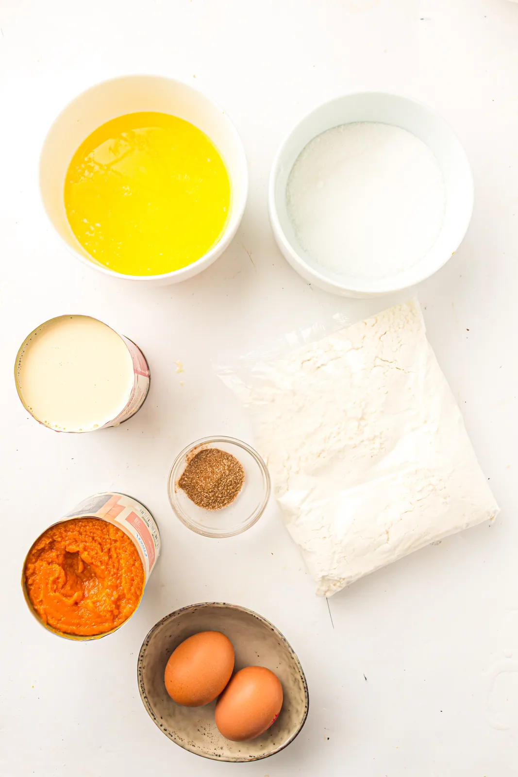 Ingredients for pumpkin dump cake: pumpkin puree, evaporated milk, eggs, sugar, spice, cake mix and melted butter
