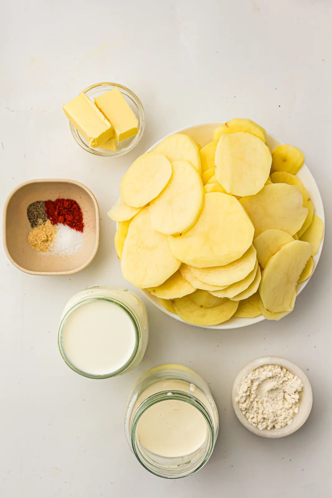 Ingredients for scalloped potatoes without cheese: sliced potatoes, butter, cream, milk, flour and seasonings