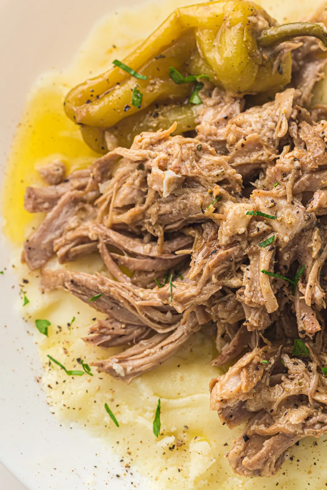 Shredded meat piled over buttery mashed potato with pickled peppers