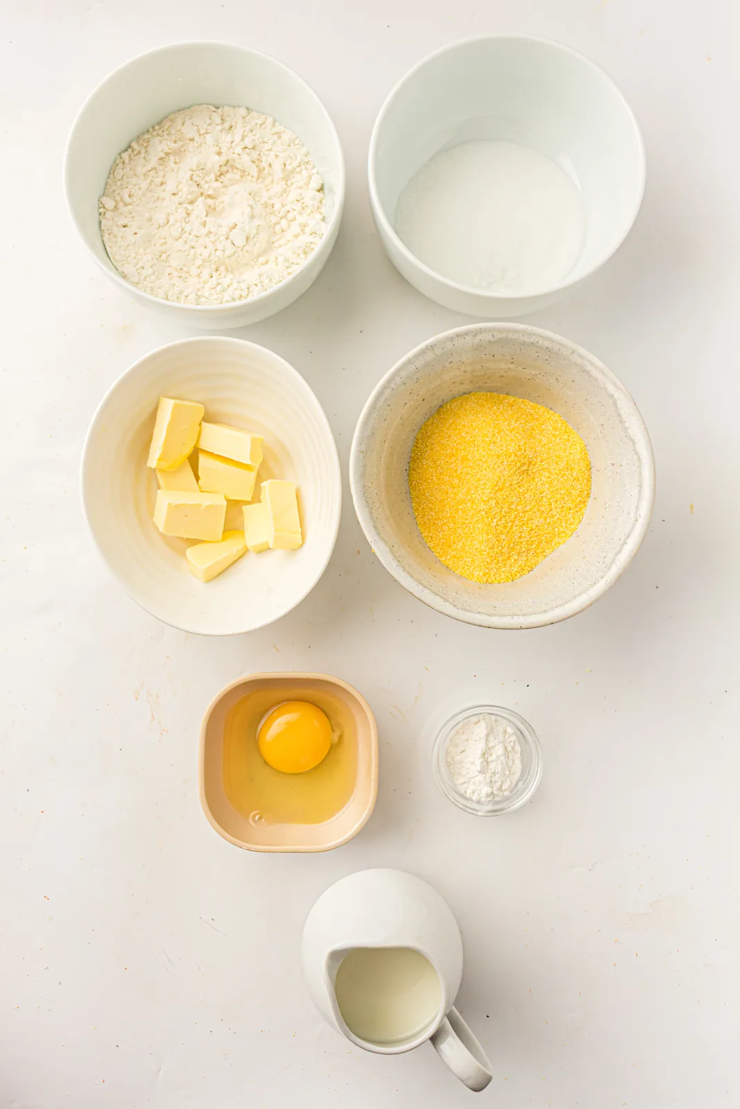 Ingredients for skillet cornbread: cornmeal, flour, sugar, baking powder, milk, egg and butter