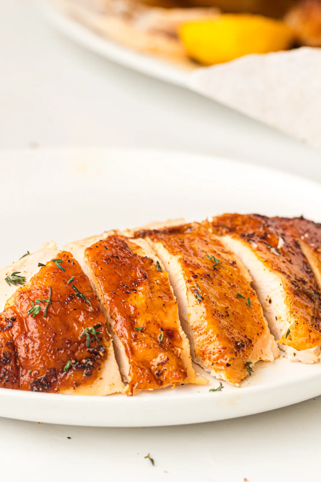 Sliced white meat arranged on a serving platter with herbs
