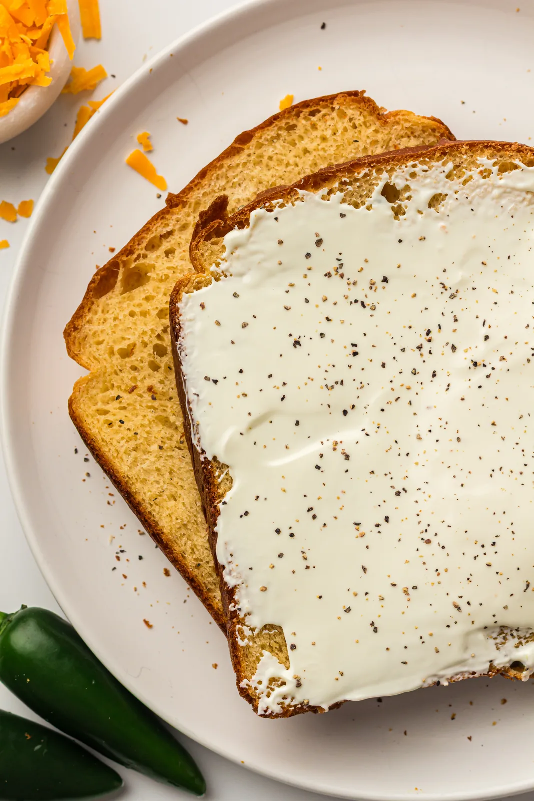 Two slices spread thickly with soft cheese and cracked pepper