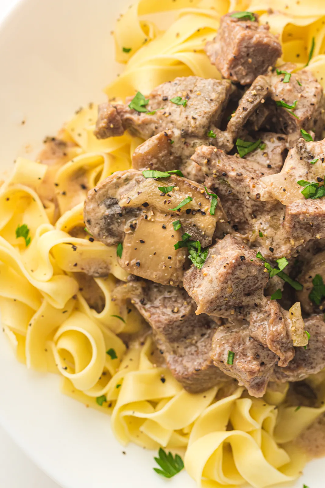 A plate of slow cooker beef stroganoff spooned over wide egg noodles