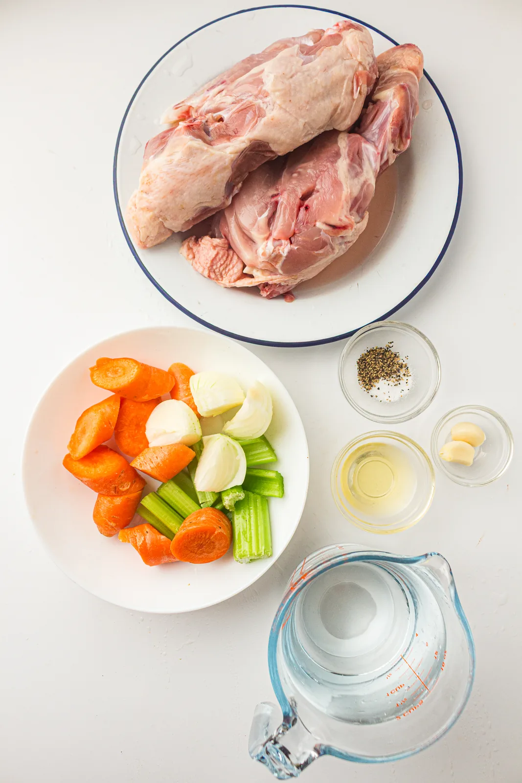 Ingredients for slow cooker chicken stock: bones, onion, carrots, celery, garlic and water