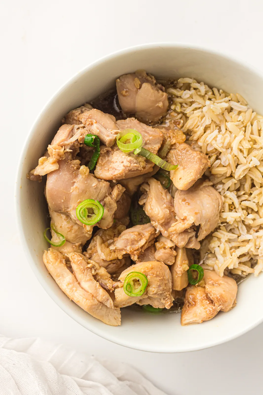Slow cooker honey garlic chicken served over rice in a white bowl