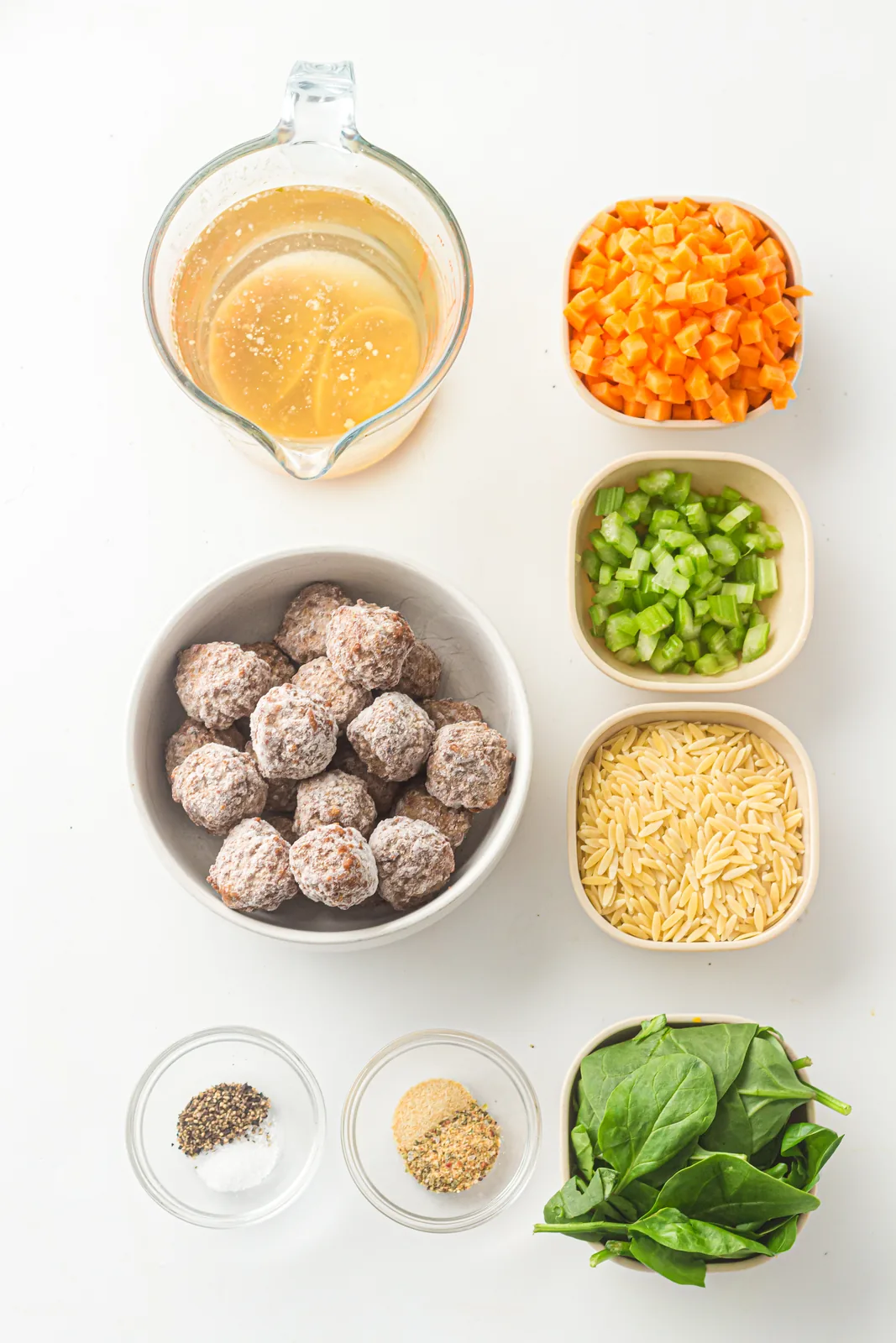 Ingredients for slow cooker italian wedding soup: broth, meatballs, orzo, carrot, celery, spinach and seasoning
