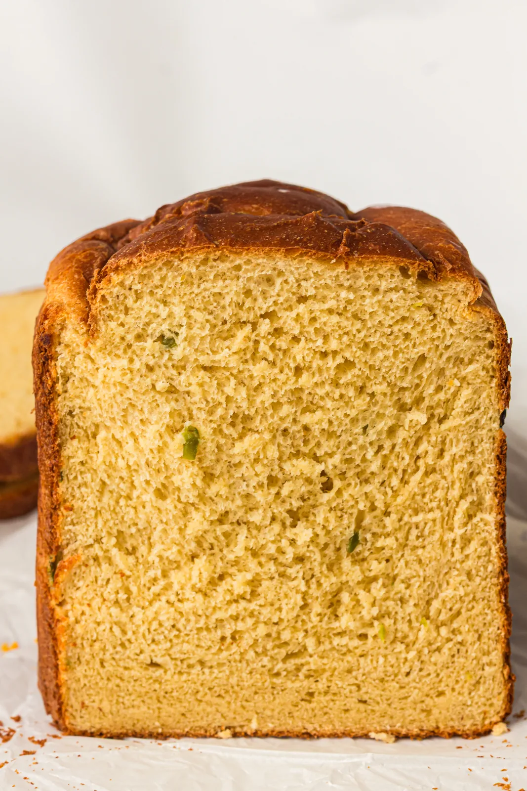 Close up of the soft crumb showing melted cheese and green pepper flecks