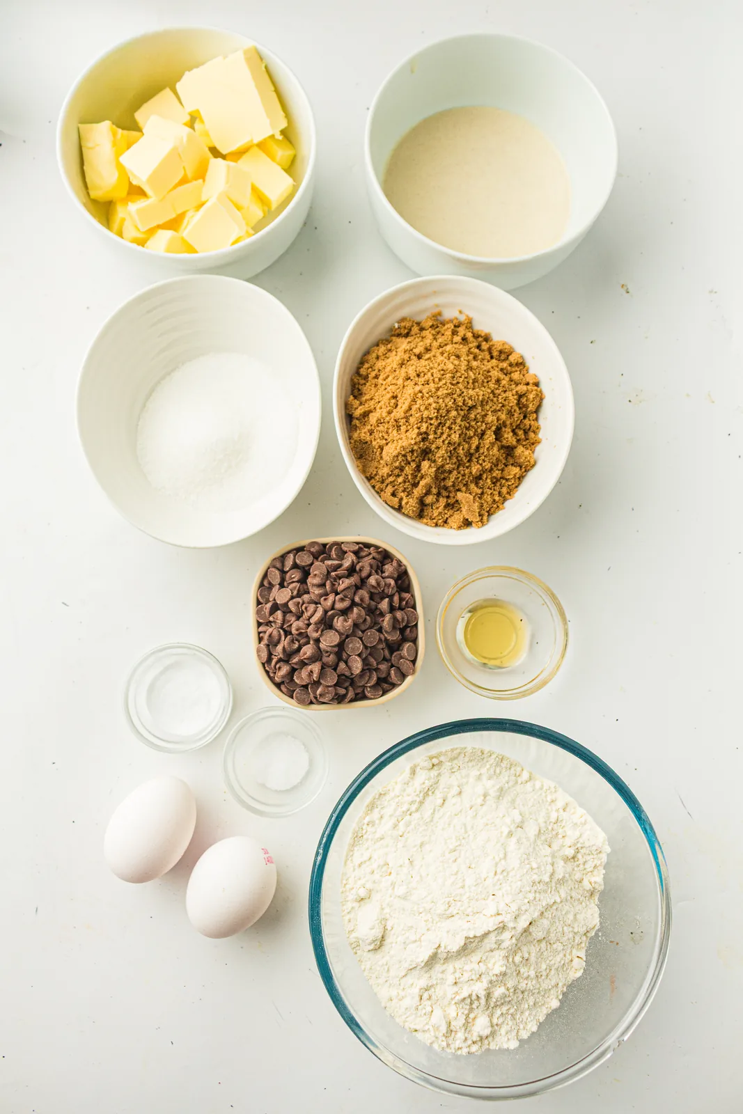 Ingredients for sourdough discard cookies: butter, brown and white sugar, eggs, flour, discard and chocolate chips